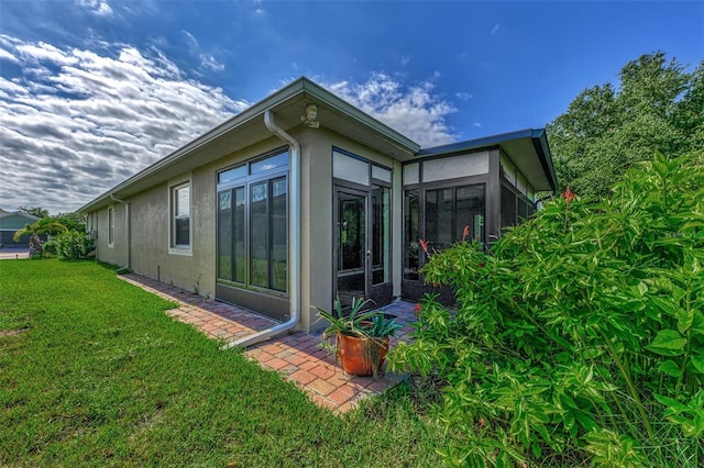 back of property with a yard and a sunroom