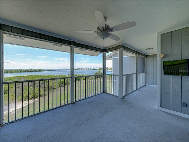 unfurnished sunroom with a water view and ceiling fan