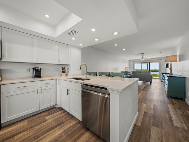 kitchen featuring sink, dark hardwood / wood-style flooring, dishwasher, kitchen peninsula, and white cabinets