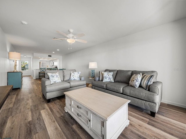 living room with ceiling fan and dark hardwood / wood-style flooring