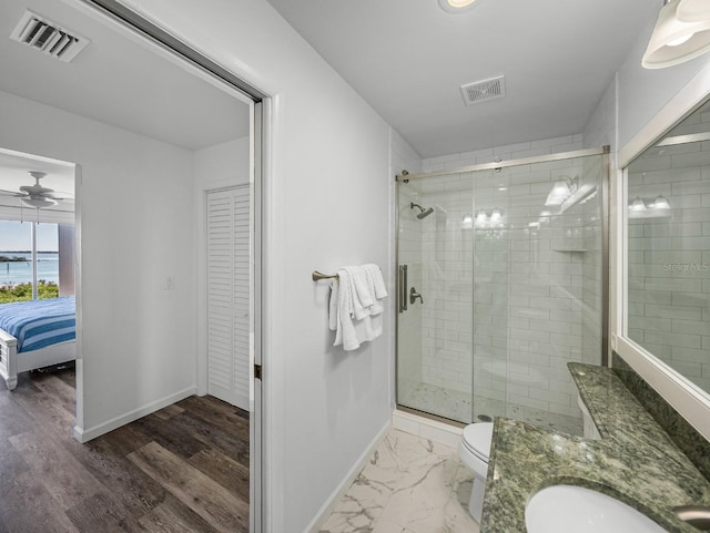 bathroom with vanity, ceiling fan, a shower with shower door, and toilet