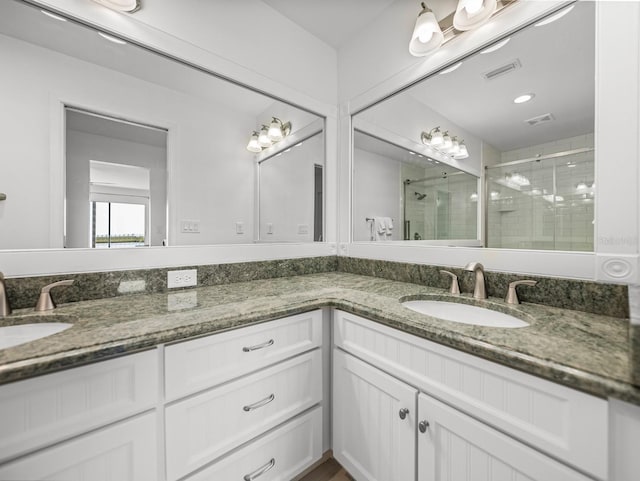 bathroom with vanity and a shower with shower door