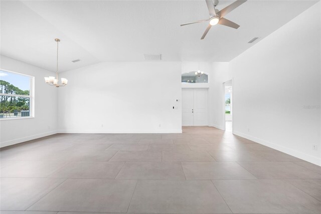 unfurnished room featuring ceiling fan with notable chandelier, vaulted ceiling, and light tile patterned flooring