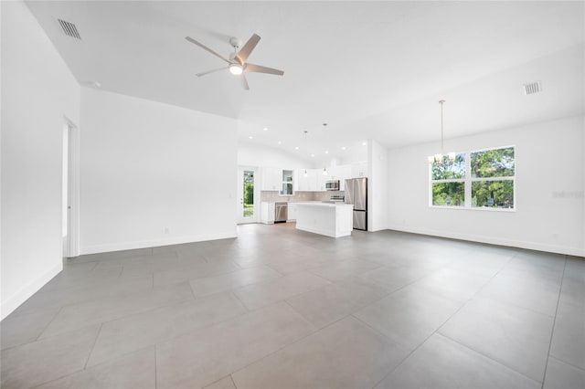 unfurnished living room with ceiling fan with notable chandelier, vaulted ceiling, and light tile patterned floors