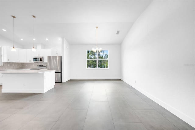 kitchen featuring appliances with stainless steel finishes, a center island, light countertops, and decorative light fixtures