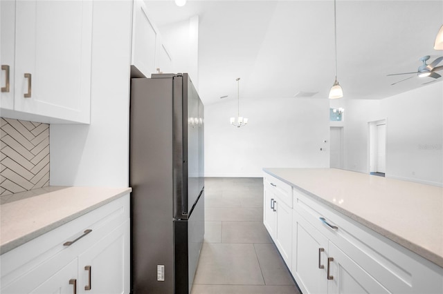 kitchen with tile patterned flooring, stainless steel fridge, white cabinetry, tasteful backsplash, and ceiling fan