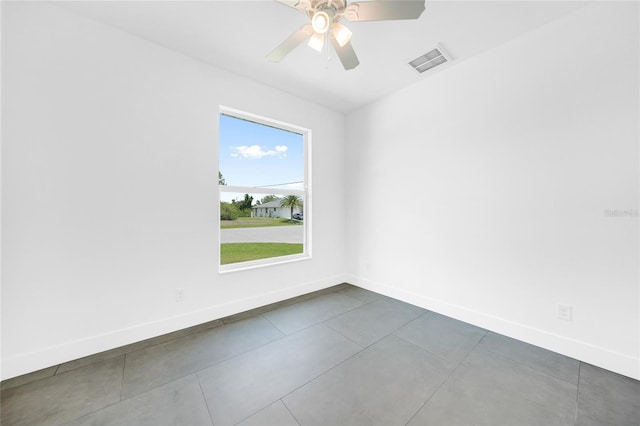 tiled spare room featuring ceiling fan and a healthy amount of sunlight