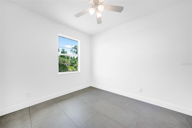 spare room with ceiling fan and baseboards