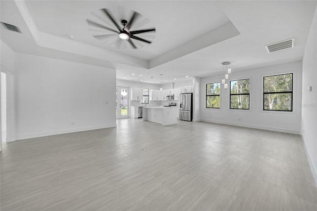 9262 Genesee St, Port Charlotte, FL 33981 - unfurnished living room featuring a raised ceiling, ceiling fan, and recessed lighting