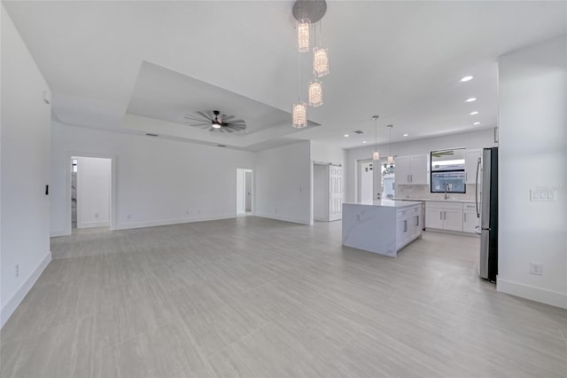 9262 Genesee St, Port Charlotte, FL 33981 - unfurnished living room featuring a ceiling fan, recessed lighting, and a raised ceiling