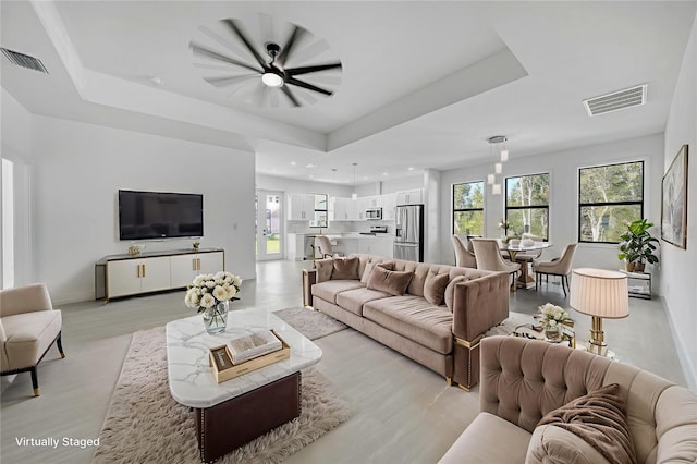 9262 Genesee St, Port Charlotte, FL 33981 - living room featuring a raised ceiling, plenty of natural light, and light wood-style floors