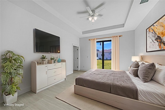 9262 Genesee St, Port Charlotte, FL 33981 - bedroom featuring a tray ceiling, access to outside, light wood finished floors, and ceiling fan