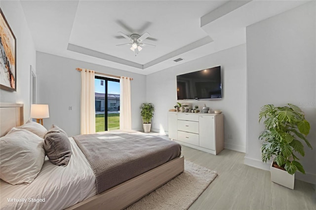 9262 Genesee St, Port Charlotte, FL 33981 - bedroom featuring a raised ceiling, light wood finished floors, access to outside, and ceiling fan