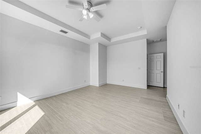 9262 Genesee St, Port Charlotte, FL 33981 - empty room with a raised ceiling, a ceiling fan, and light wood-style floors