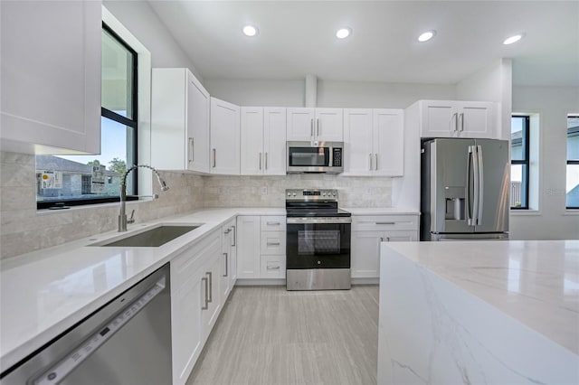 9262 Genesee St, Port Charlotte, FL 33981 - kitchen with appliances with stainless steel finishes, light stone countertops, white cabinetry, and recessed lighting
