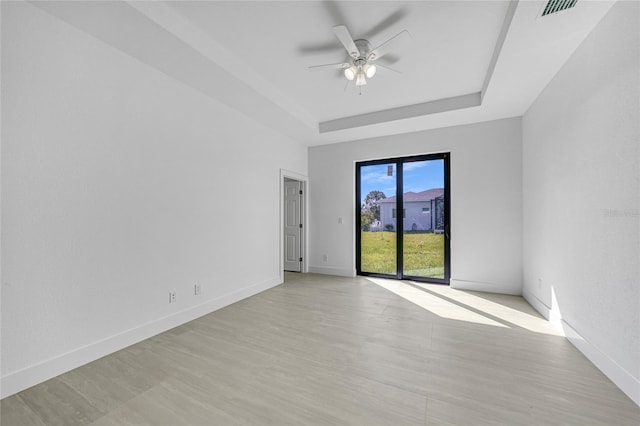 9262 Genesee St, Port Charlotte, FL 33981 - empty room with a ceiling fan, light wood-style flooring, and a raised ceiling