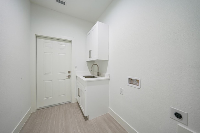 9262 Genesee St, Port Charlotte, FL 33981 - washroom featuring hookup for an electric dryer, light wood-type flooring, cabinet space, and washer hookup