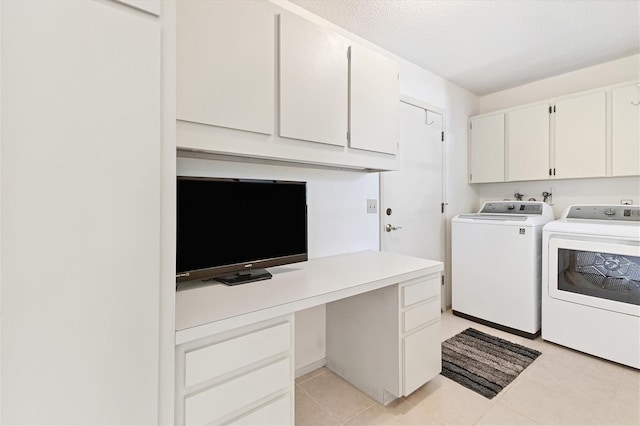 washroom with cabinets, washing machine and dryer, a textured ceiling, and light tile patterned floors