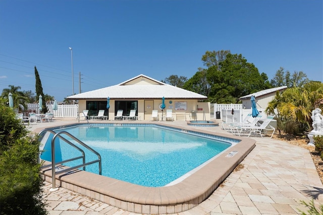 view of swimming pool featuring a community hot tub and a patio