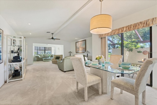 dining room featuring vaulted ceiling with beams, plenty of natural light, and light colored carpet