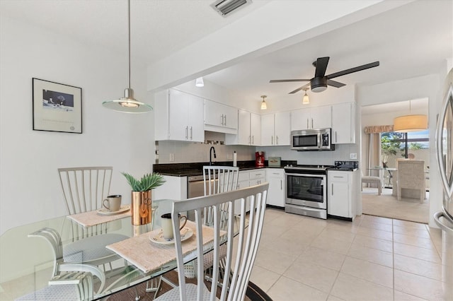 kitchen featuring pendant lighting, backsplash, white cabinetry, and stainless steel appliances