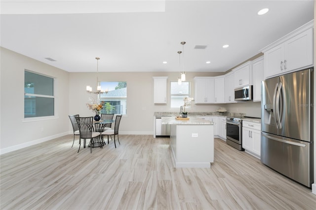 kitchen featuring light hardwood / wood-style flooring, a kitchen island, stainless steel appliances, and white cabinets