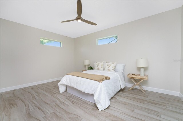 bedroom with multiple windows, ceiling fan, and light hardwood / wood-style flooring