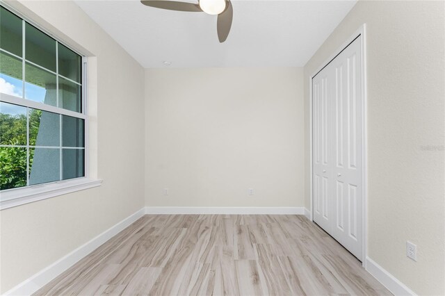 unfurnished bedroom featuring ceiling fan, a closet, and light hardwood / wood-style floors