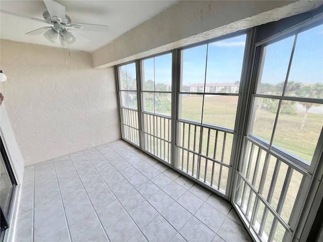 unfurnished sunroom featuring ceiling fan