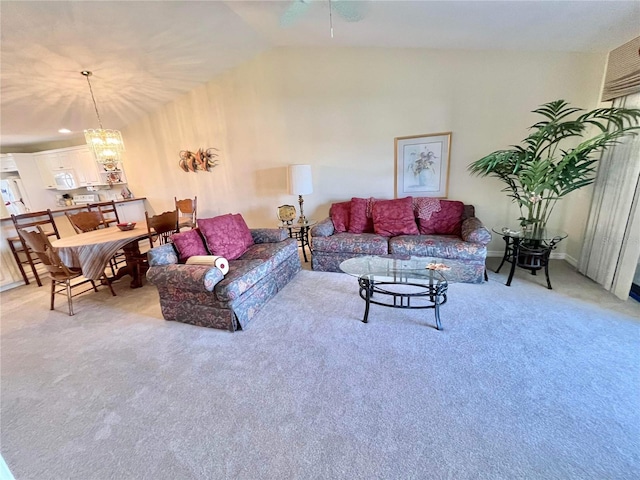 living room with lofted ceiling, a chandelier, and carpet