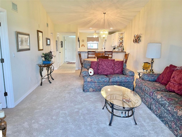 carpeted living room with a notable chandelier