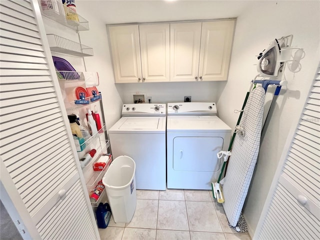 clothes washing area featuring cabinets, light tile patterned floors, and independent washer and dryer