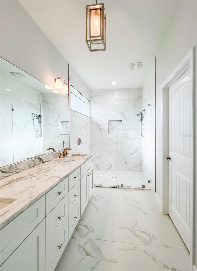 bathroom with vanity, tiled shower, and tile patterned flooring