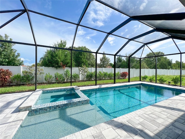 view of pool featuring a patio area, glass enclosure, and an in ground hot tub