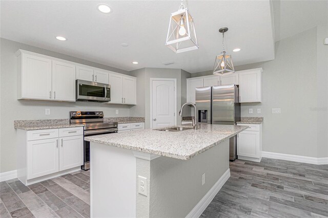 kitchen featuring white cabinets, stainless steel appliances, sink, and a center island with sink