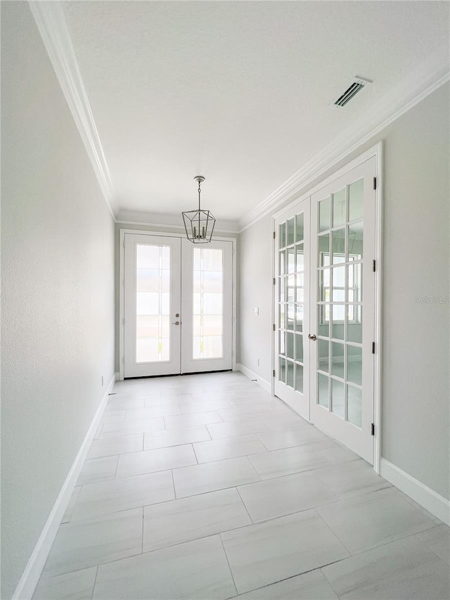 tiled empty room with ornamental molding, a chandelier, and french doors