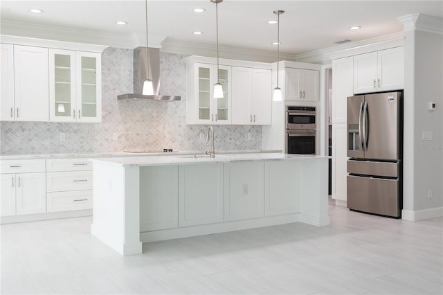 kitchen with wall chimney exhaust hood, appliances with stainless steel finishes, backsplash, and white cabinets