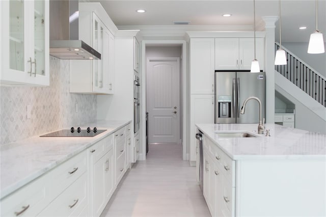 kitchen with wall chimney exhaust hood, an island with sink, stainless steel refrigerator with ice dispenser, black electric stovetop, and decorative backsplash