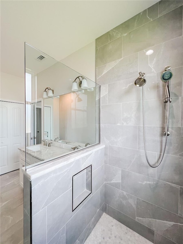 bathroom featuring vanity and tiled shower