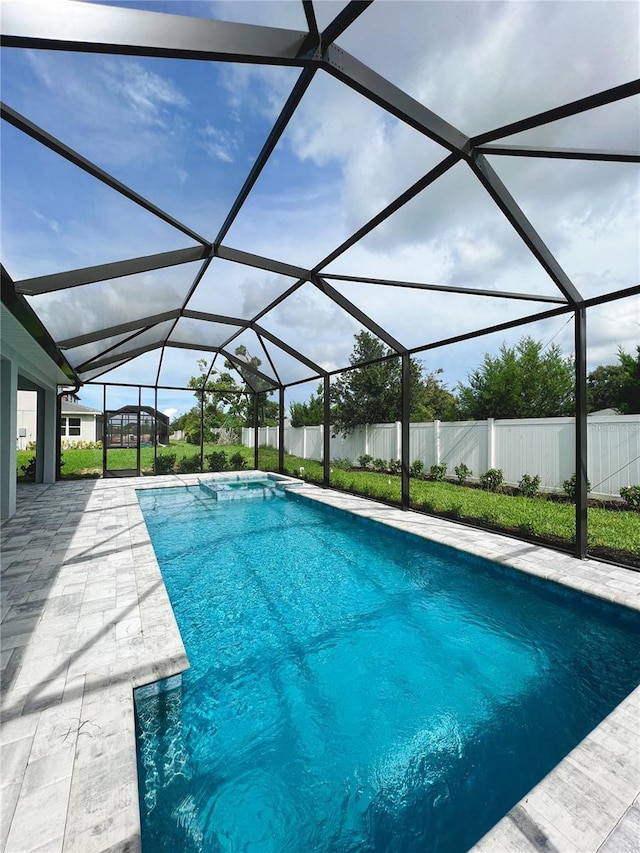 view of pool with a patio and glass enclosure