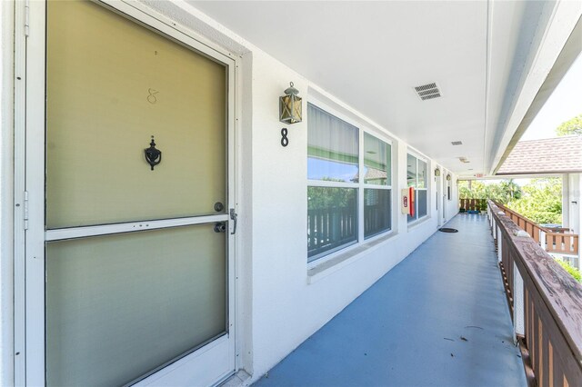 3 Quails Run Blvd Unit 8, Englewood, FL 34223 - doorway to property featuring visible vents and covered porch