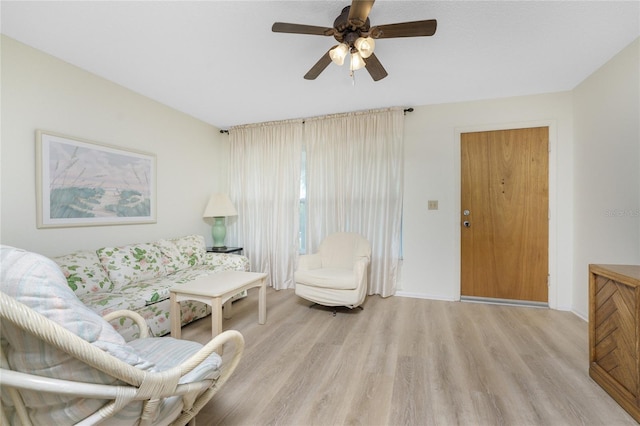 living room featuring light wood-type flooring and ceiling fan