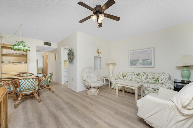 3 Quails Run Blvd Unit 8, Englewood, FL 34223 - living room featuring a textured ceiling, visible vents, ceiling fan, and light wood-style floors