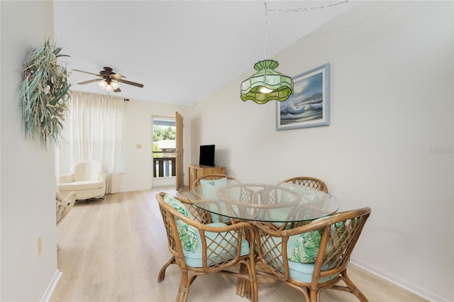 dining room with light wood-type flooring, vaulted ceiling, and ceiling fan