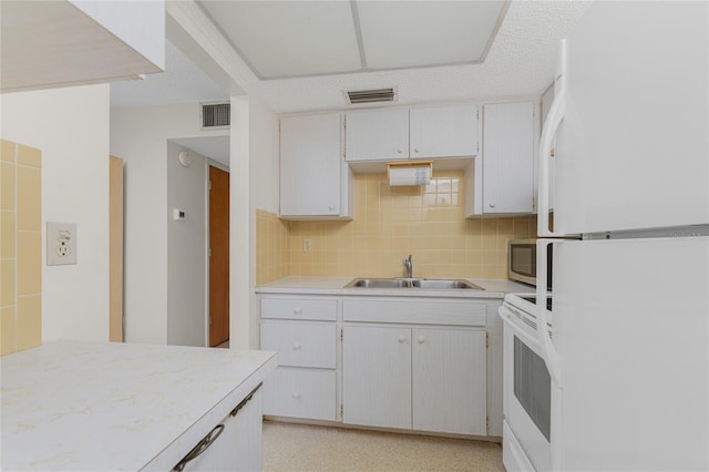 kitchen with tile walls, white appliances, sink, and decorative backsplash