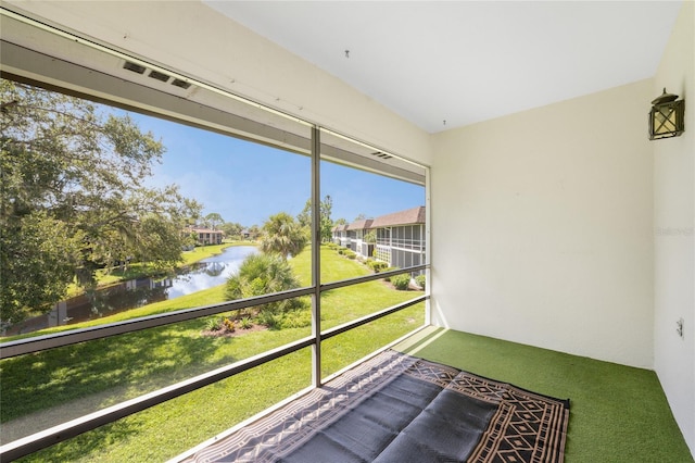 unfurnished sunroom featuring a water view