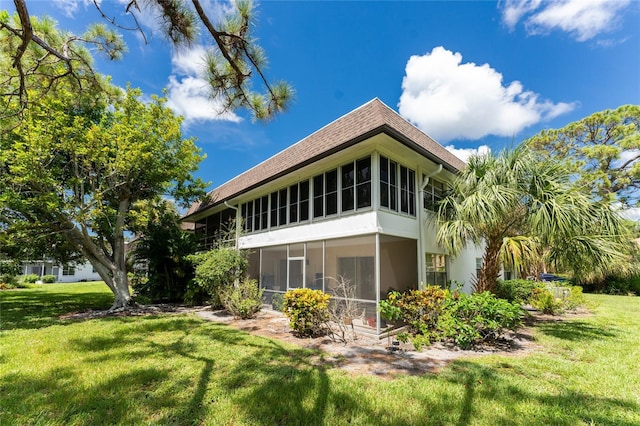 3 Quails Run Blvd Unit 8, Englewood, FL 34223 - back of property featuring a yard, a shingled roof, and a sunroom