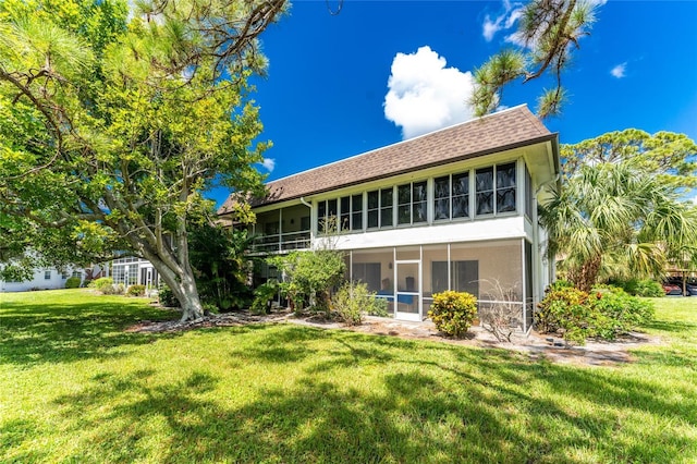 3 Quails Run Blvd Unit 8, Englewood, FL 34223 - back of house with stucco siding, a yard, a shingled roof, and a sunroom