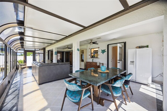 tiled dining area featuring ceiling fan and french doors