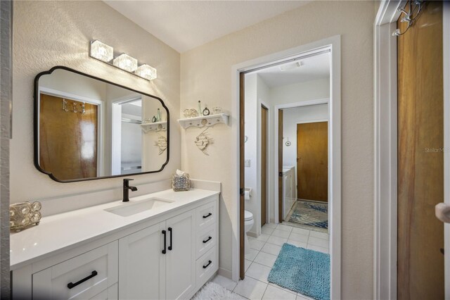 bathroom with tile patterned flooring, vanity, and toilet